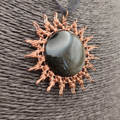 Detalle del reflejo dorado interno de la obsidiana dorada bajo la luz directa.