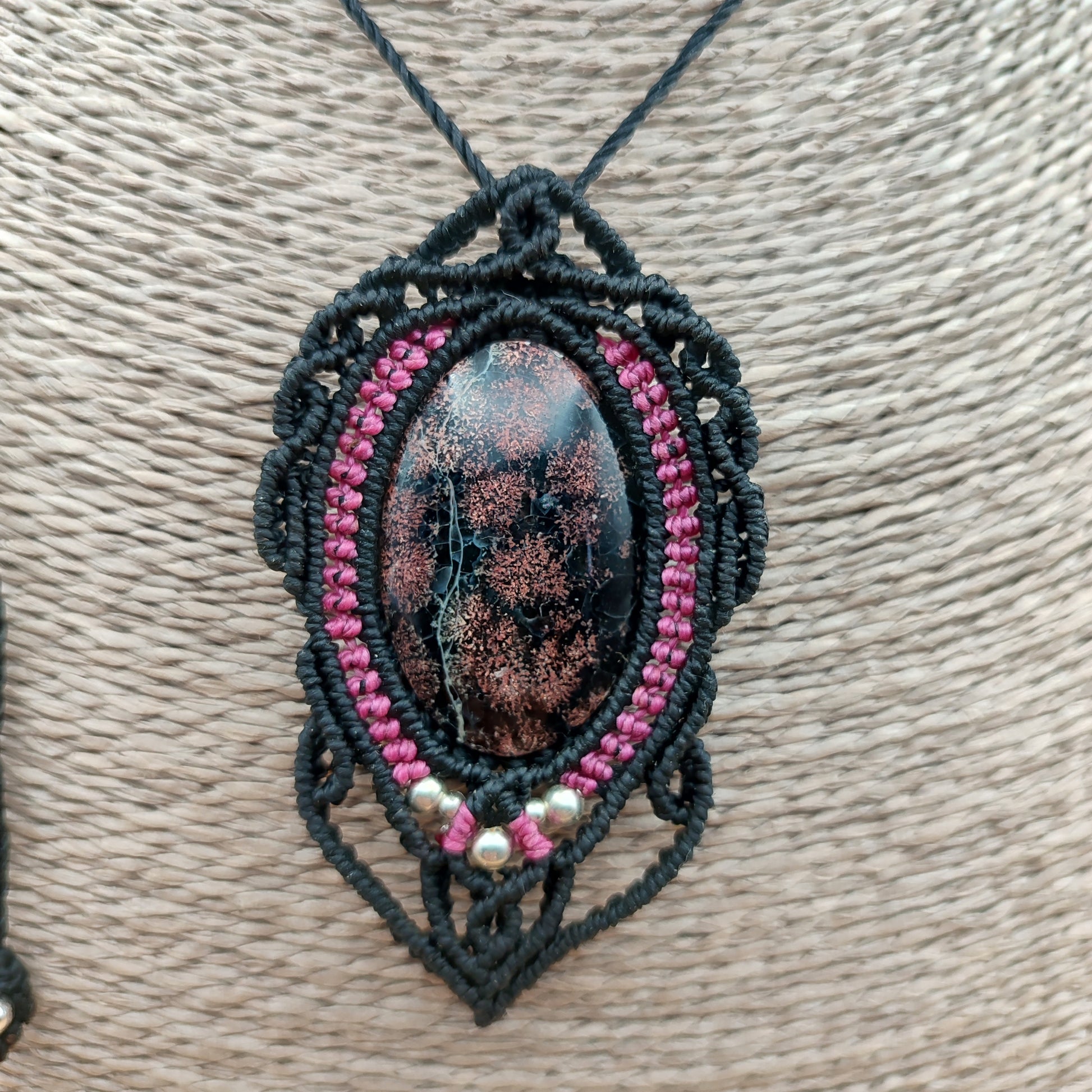 Colgante artesanal de calcedonia negra y rosa con tejido macramé de autor