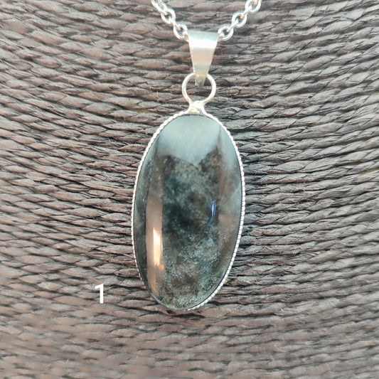 colgante artesanal de piedra obsidiana plateada natural con forma ovalada, engarzado en alpaca con baño de plata hecho a mano