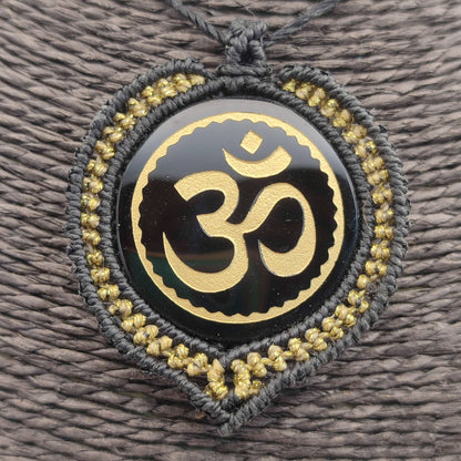 El colgante Om de Teotihuacán en la mano mostrando su brillo y acabado.