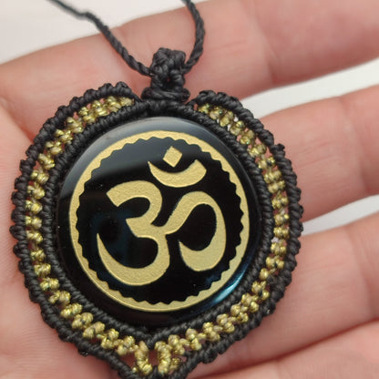 Colgante de obsidiana negra con símbolo sagrado Om grabado en dorado.