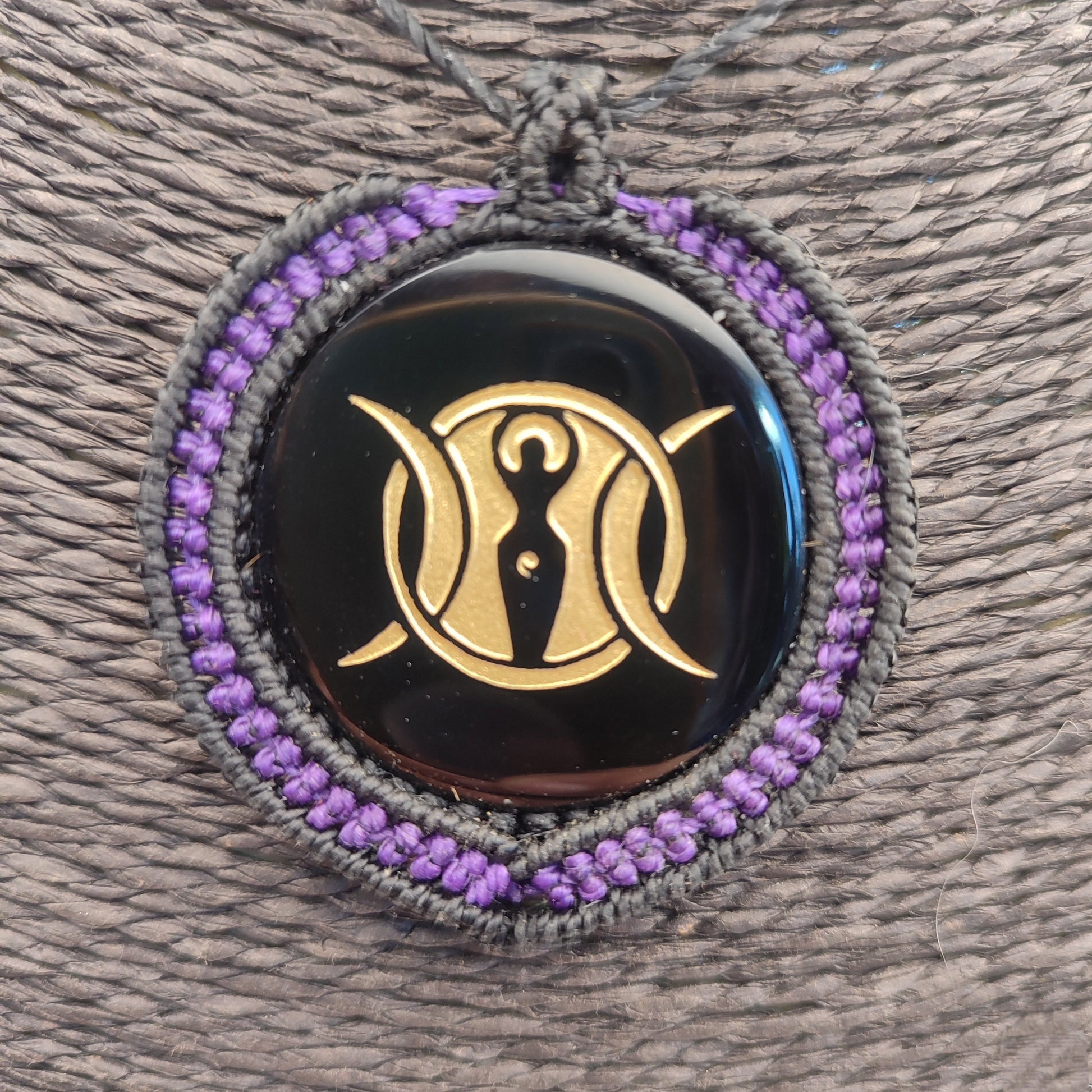 Colgante de espejo de obsidiana negra de Teotihuacan con símbolo de la Triple Diosa en dorado.