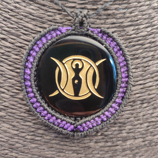 Colgante de espejo de obsidiana negra de Teotihuacan con símbolo de la Triple Diosa en dorado.