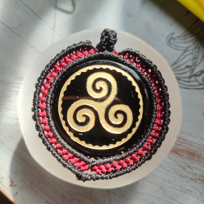 Colgante de obsidiana negra con símbolo Trisquel celta grabado en dorado.