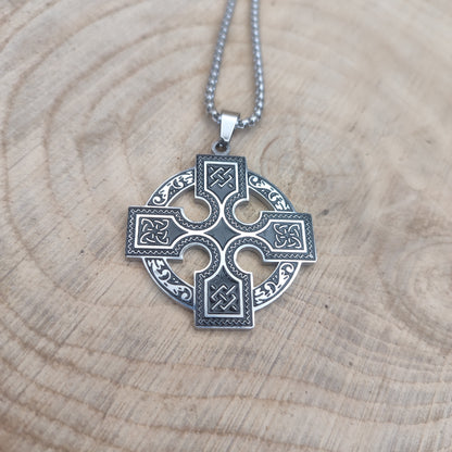 Collar de cruz celta en acero inoxidable estilo vikingo sobre madera