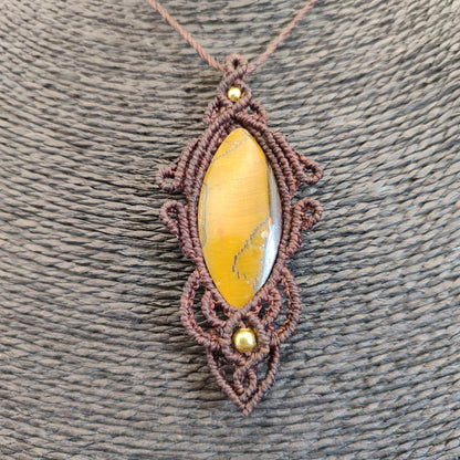 Detalle del tejido artesanal en macramé envolviendo un ojo de tigre