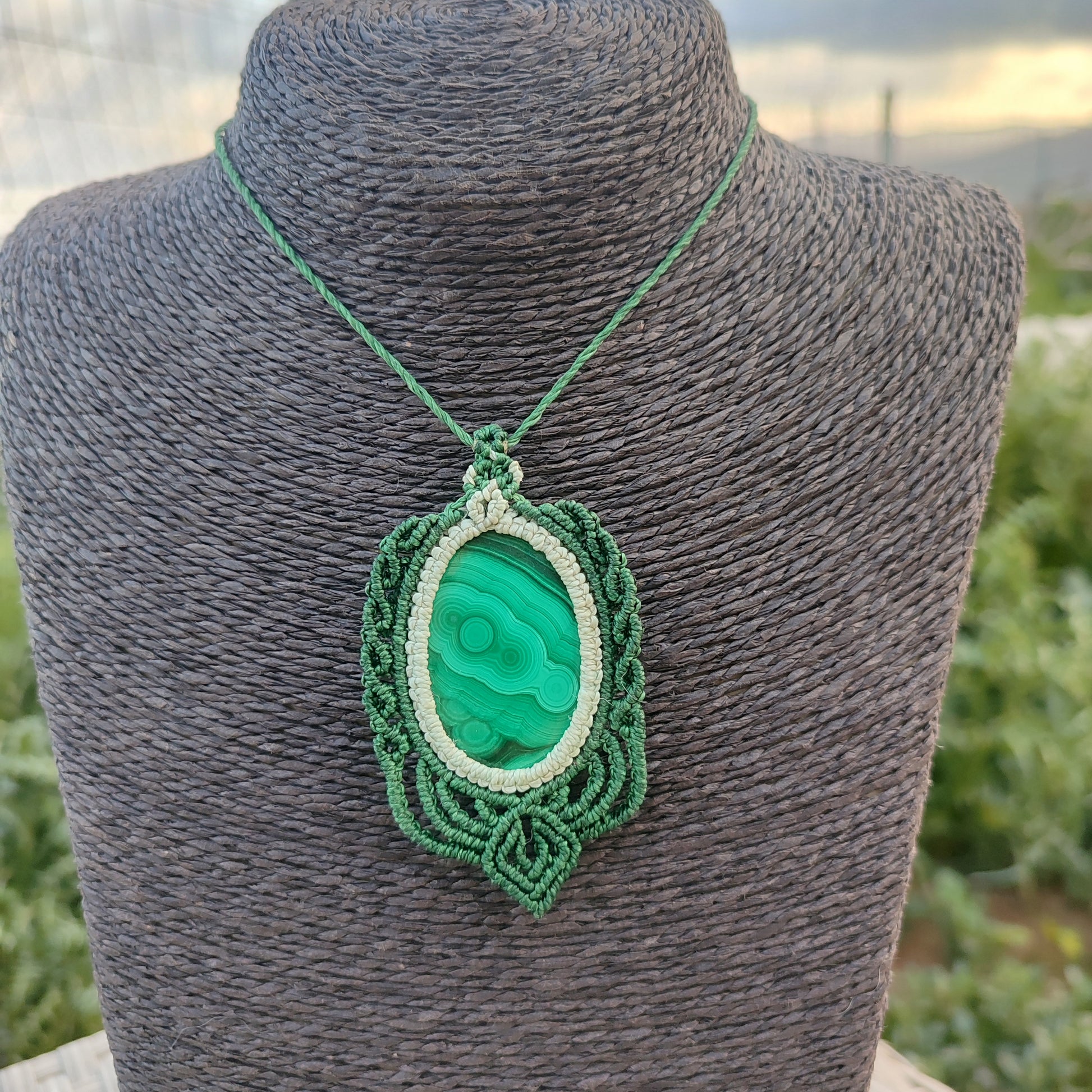 Vista del colgante de malaquita sobre busto para apreciar su imponente escala