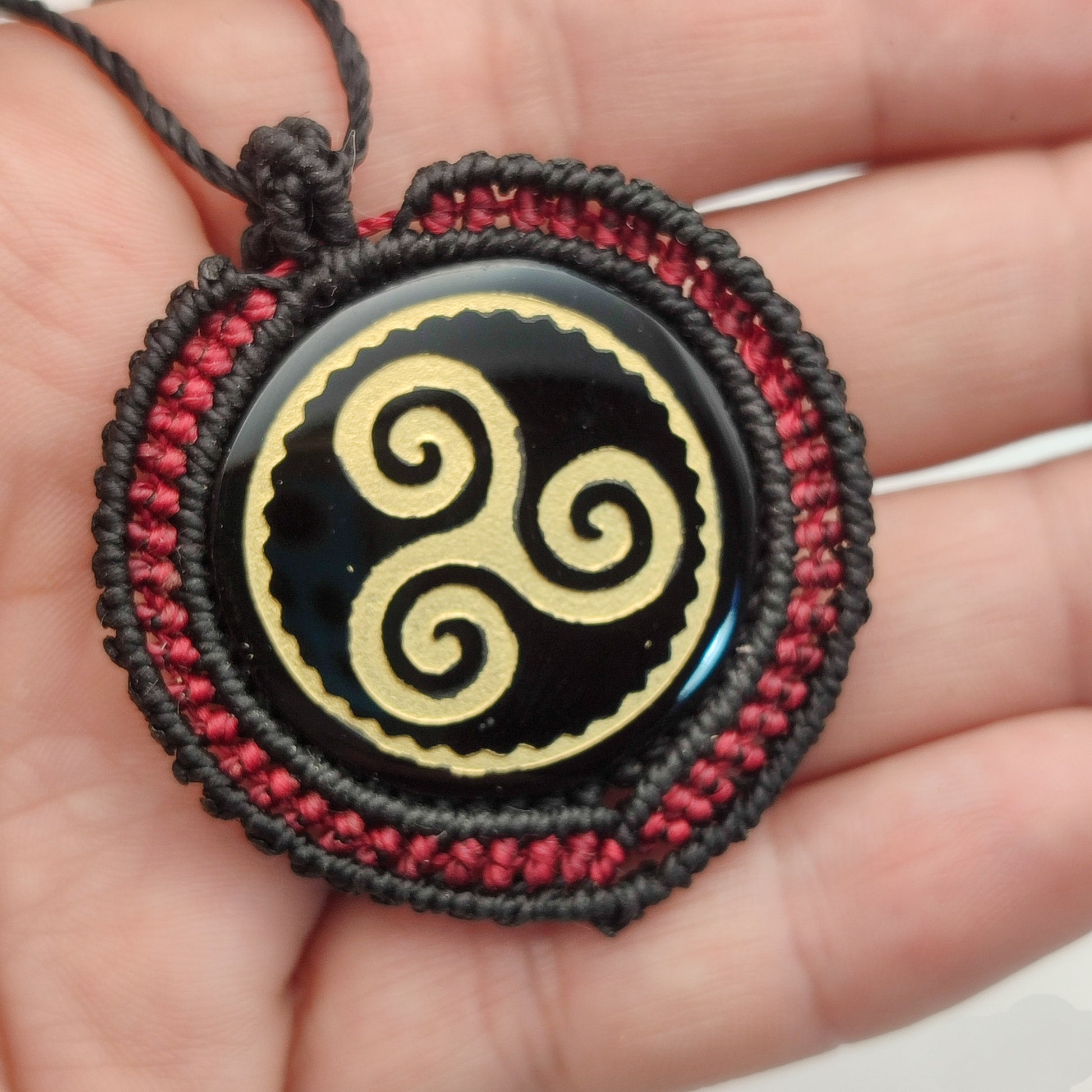 El colgante Trisquel puesto, mostrando su diseño elegante y su carga simbólica.