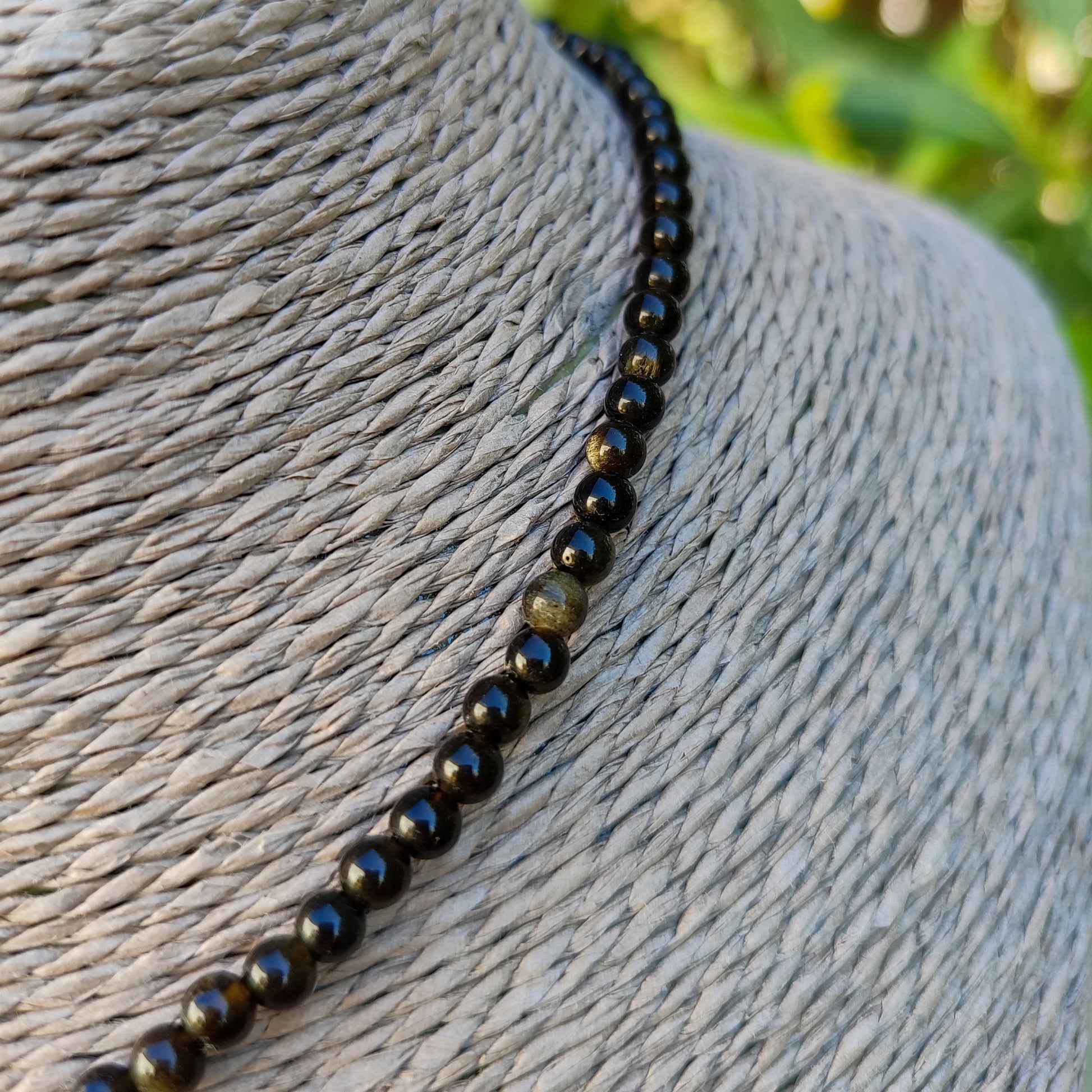 Primer plano de las cuentas de obsidiana dorada mostrando sus destellos naturales