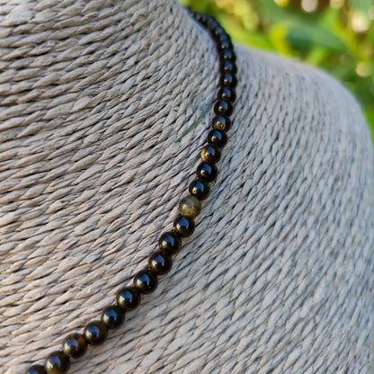 Primer plano de las cuentas de obsidiana dorada mostrando sus destellos naturales