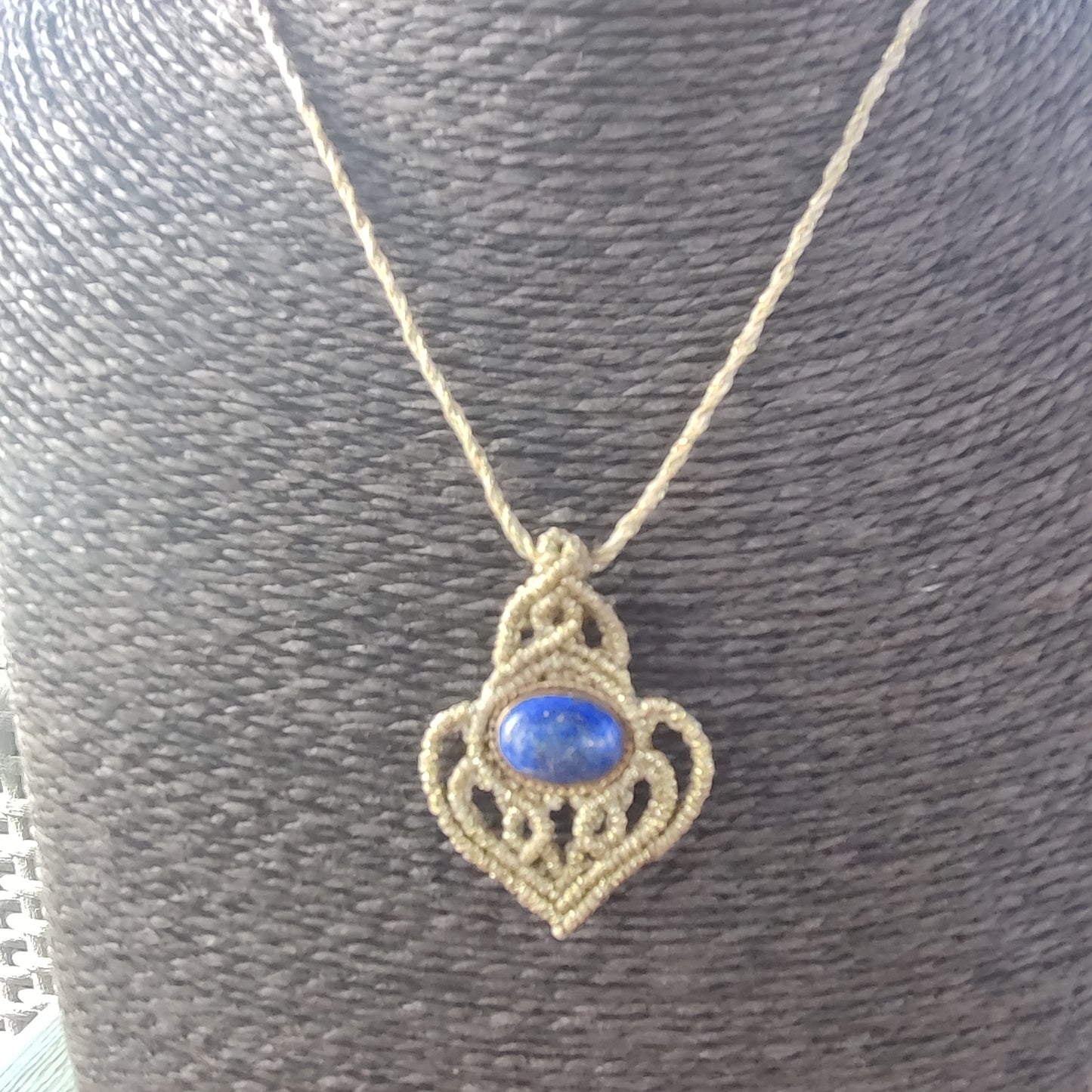 Colgante de lapislázuli en la mano mostrando su tamaño discreto