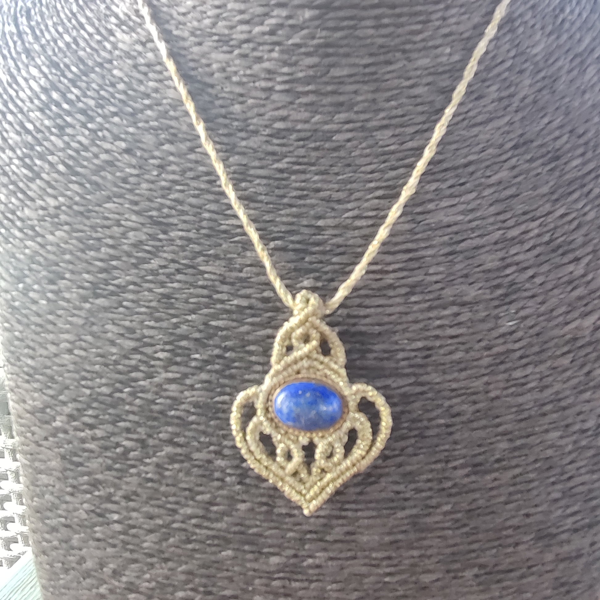 Colgante de lapislázuli en la mano mostrando su tamaño discreto