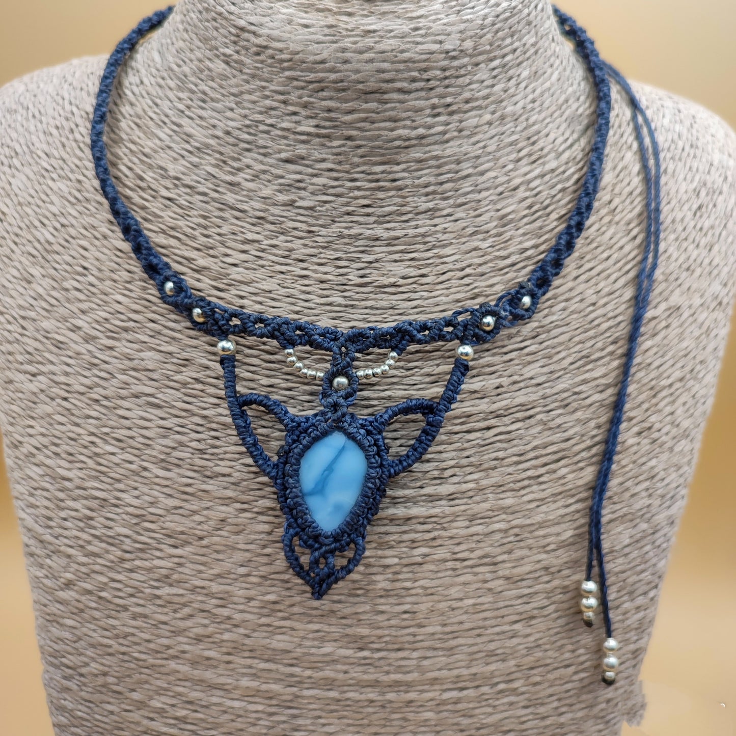 El collar de ópalo azul en la mano para mostrar el tamaño real y la calidad del acabado.