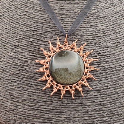 Primer plano de la técnica artesanal de cobre envolviendo la obsidiana.