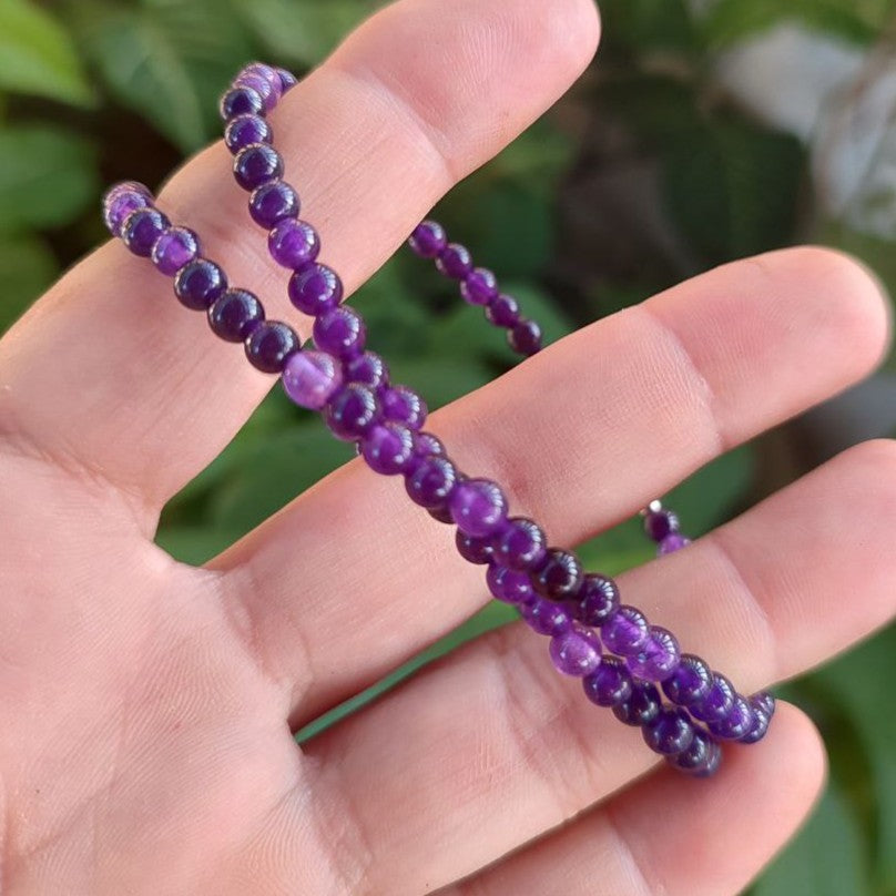 Detalle del collar de amatista de 4mm sujeto en la mano.