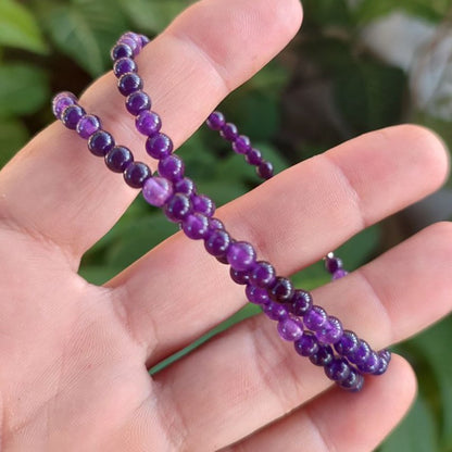 Detalle del collar de amatista de 4mm sujeto en la mano.