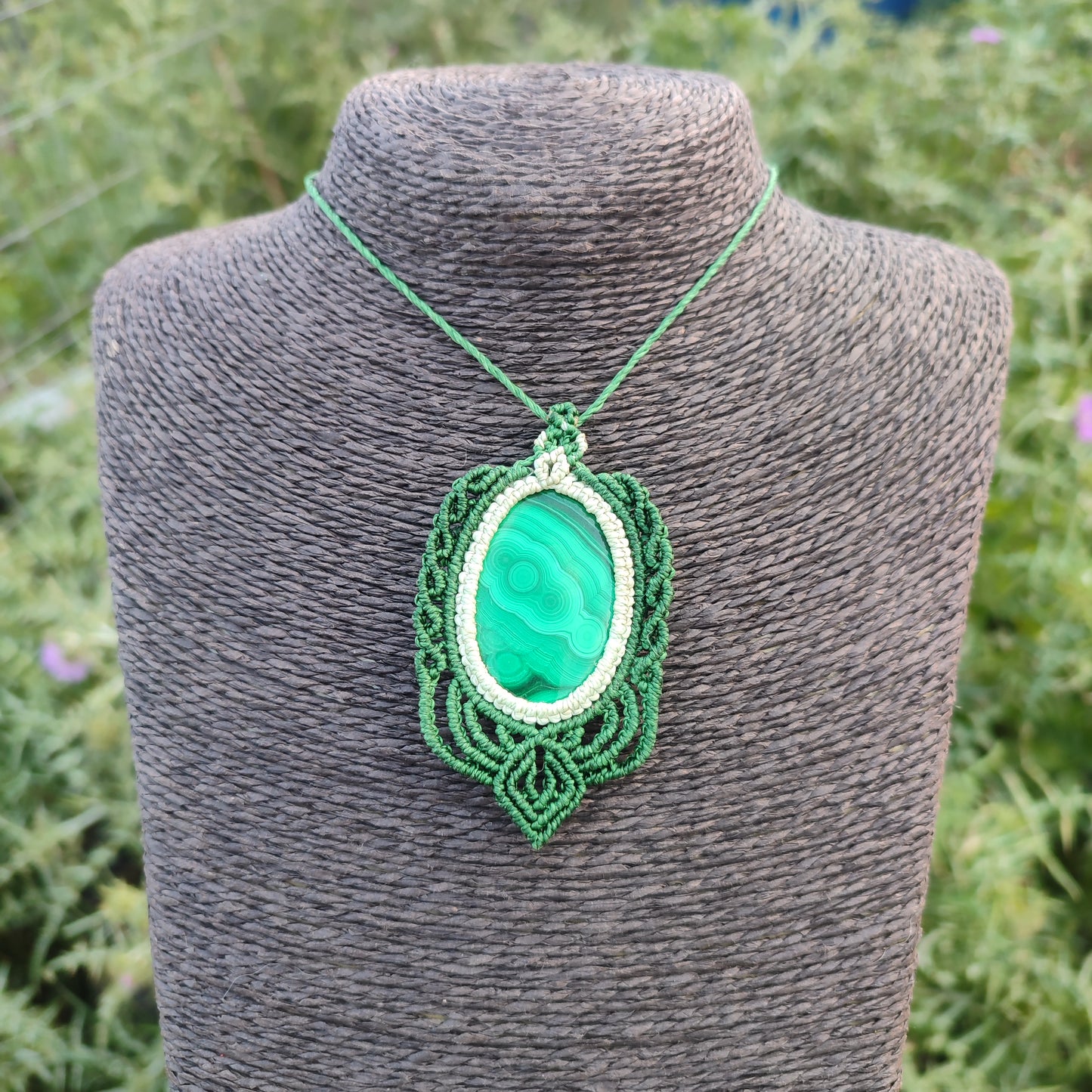 Detalle del micro-macramé artesanal envolviendo una malaquita de gran tamaño