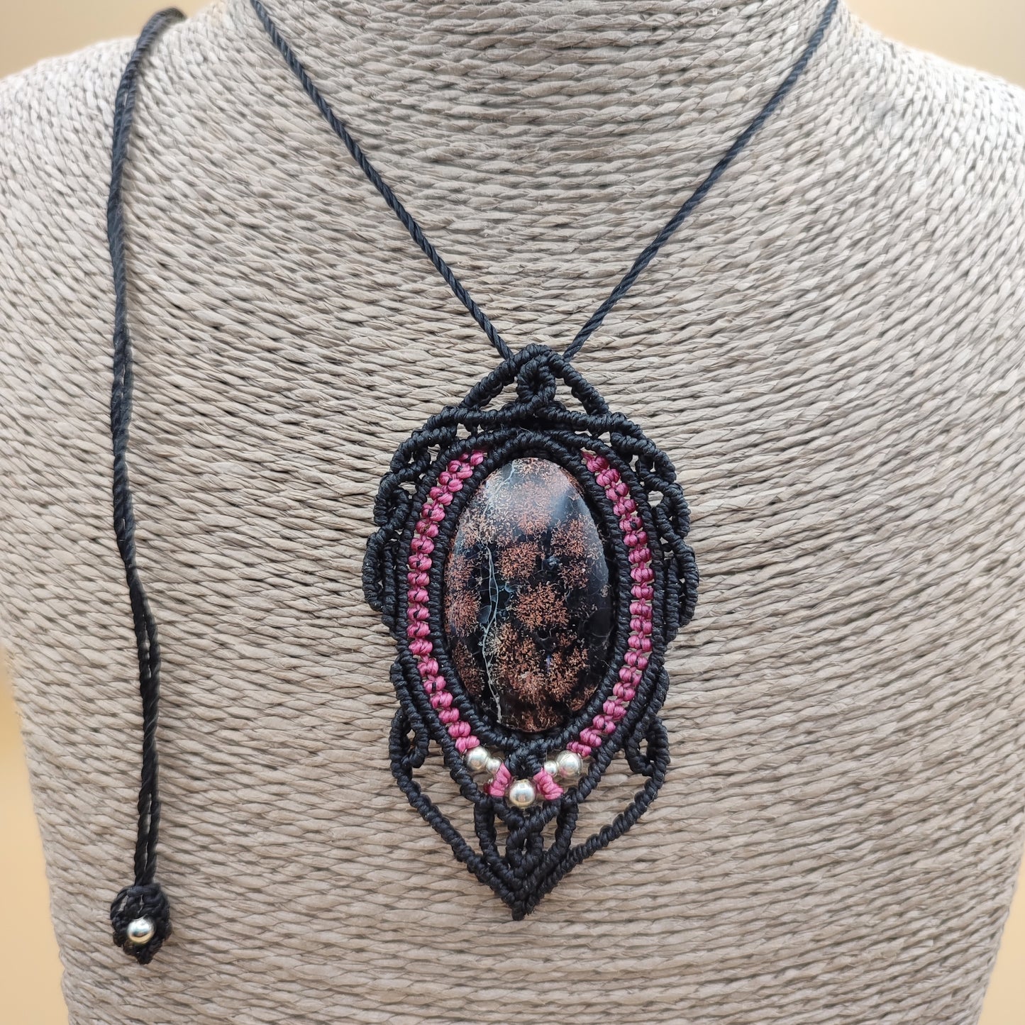 Detalle del micro-macramé bicolor negro y rosa envolviendo la calcedonia