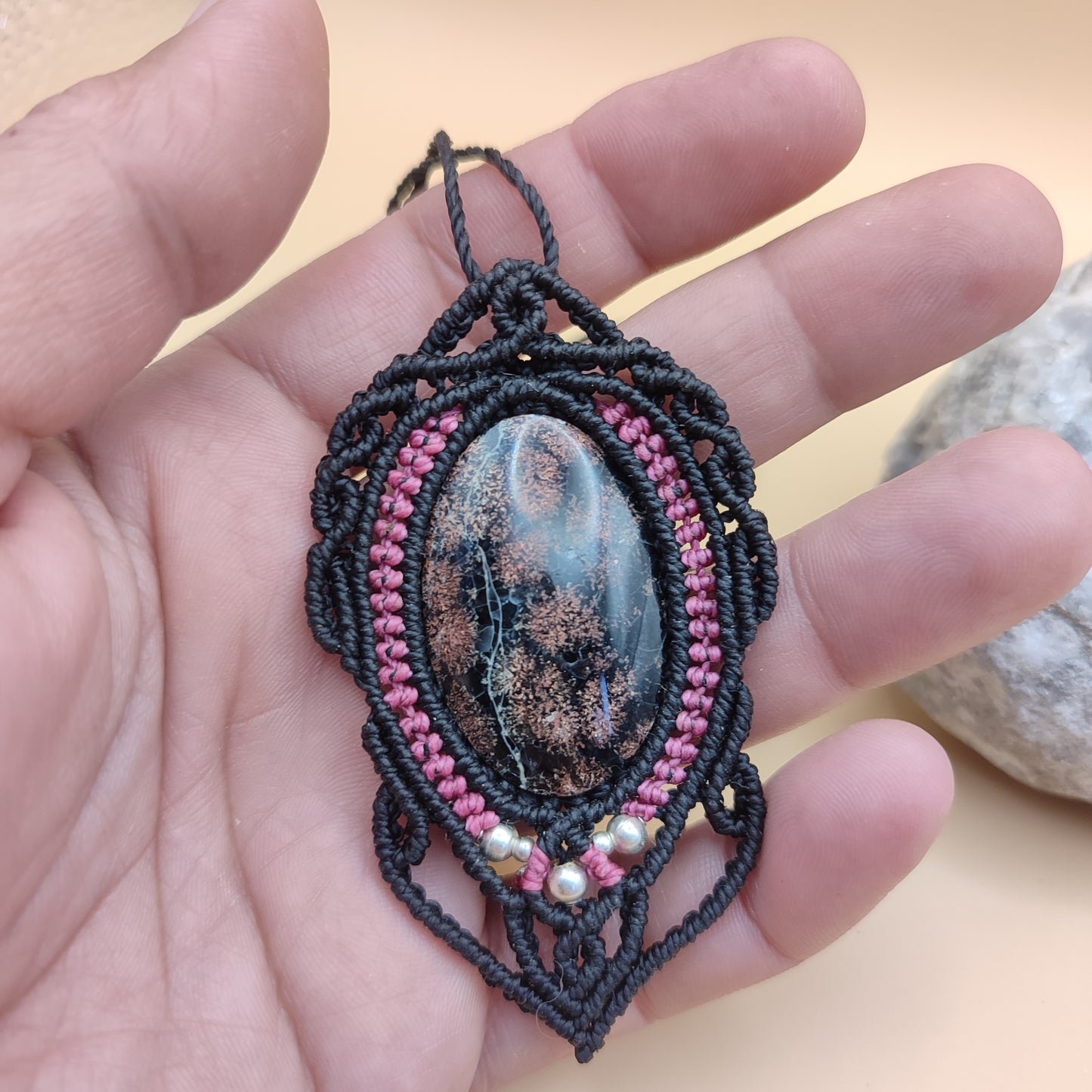 Tamaño real de la calcedonia negra y rosa en la mano para ver escala