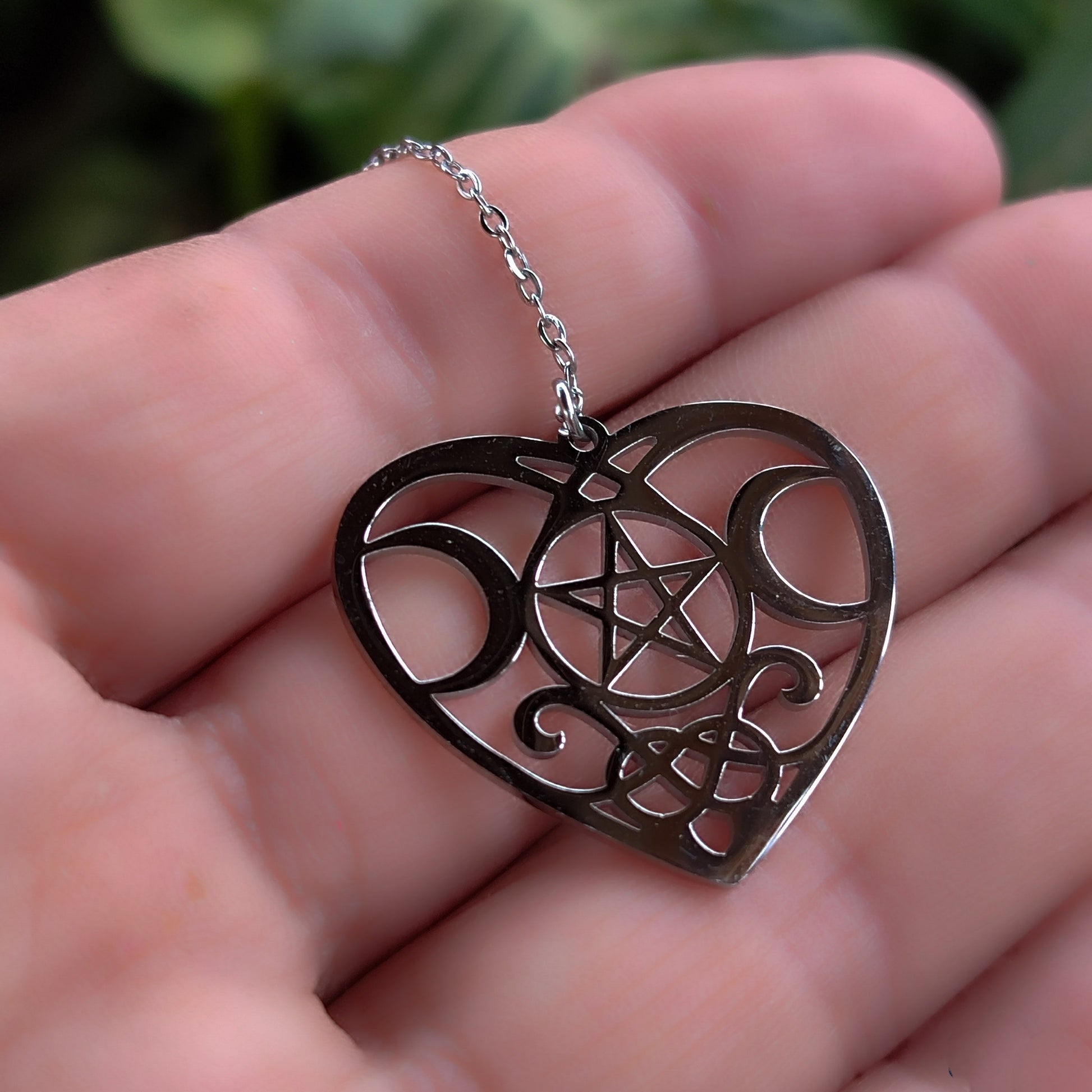 Detalle del tamaño del colgante corazón con pentagrama en la mano