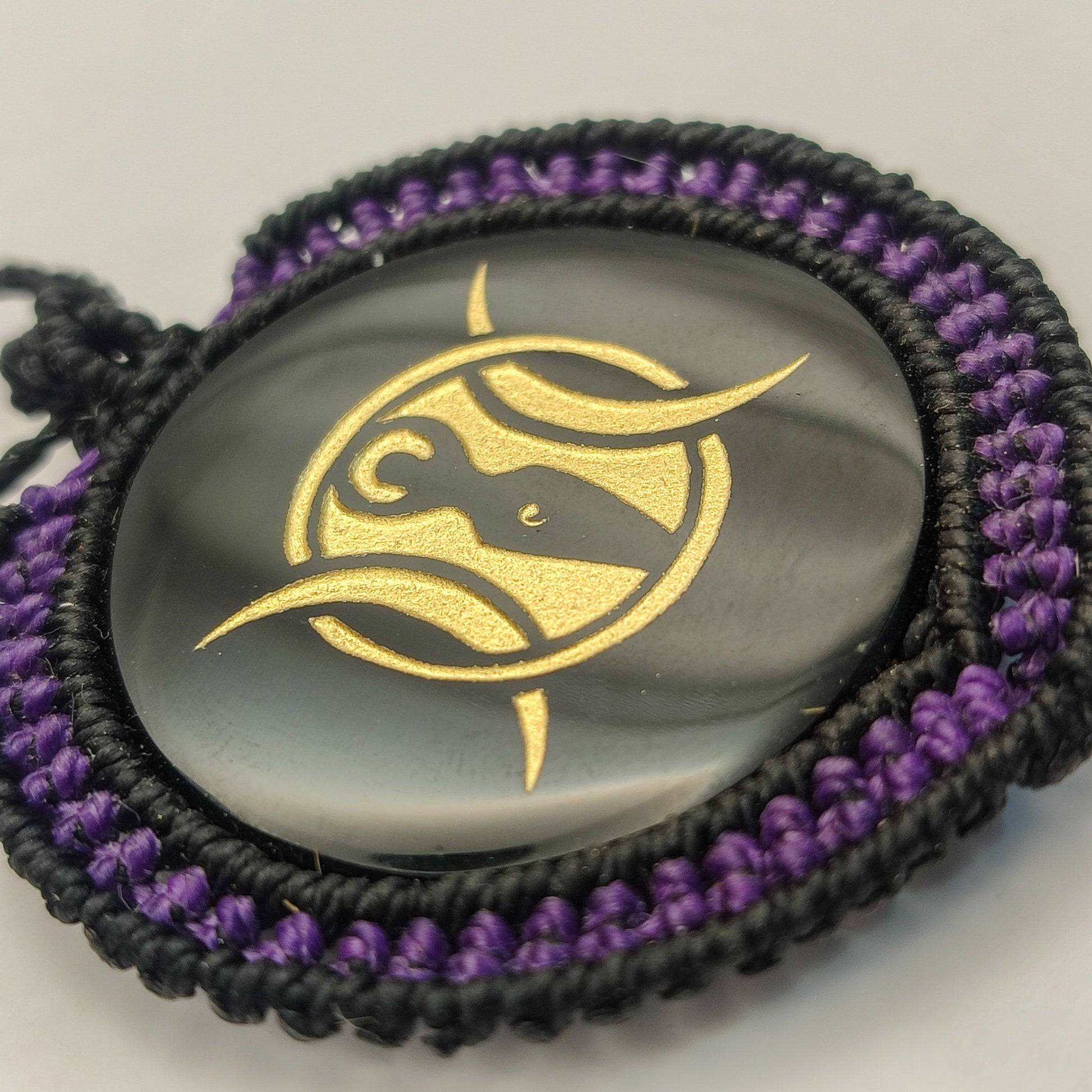 Vista del reflejo del espejo de obsidiana y el contraste con el tejido macramé púrpura.