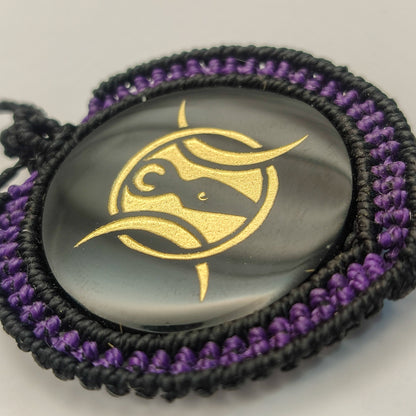 Vista del reflejo del espejo de obsidiana y el contraste con el tejido macramé púrpura.