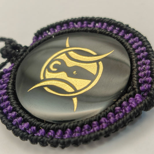 Vista del reflejo del espejo de obsidiana y el contraste con el tejido macramé púrpura.