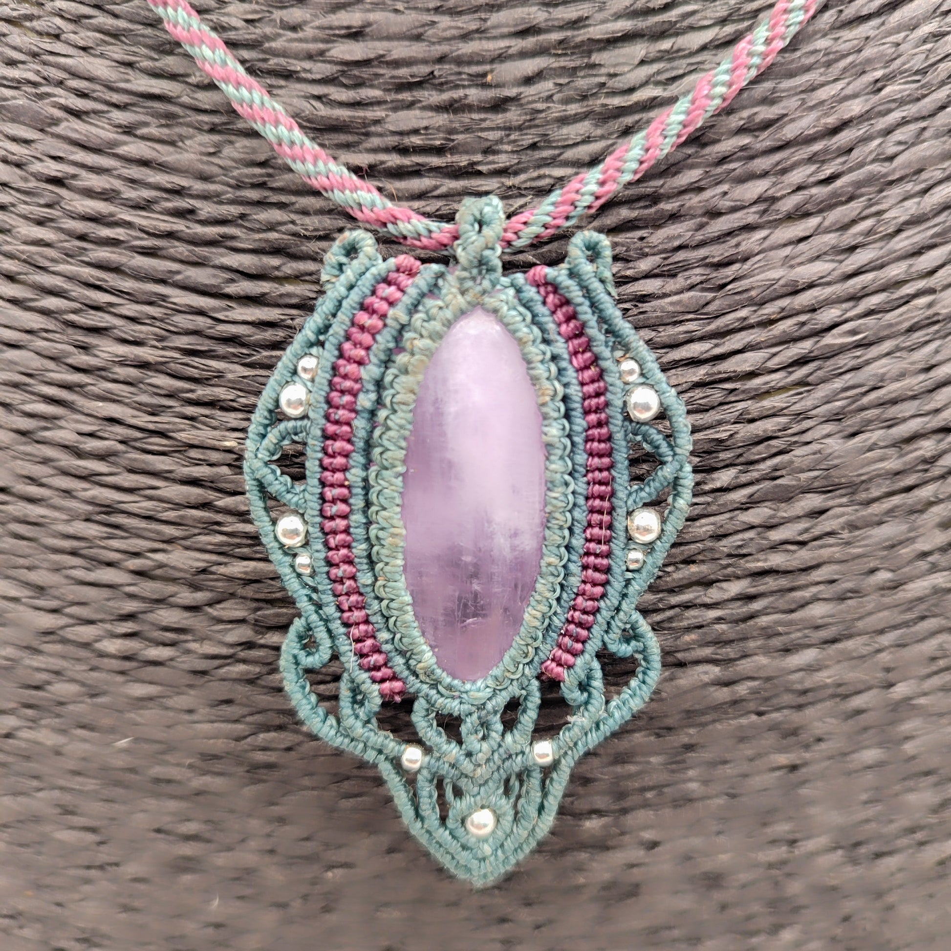 Piedra kuncita natural de color rosa malva engarzada en hilo verde agua.