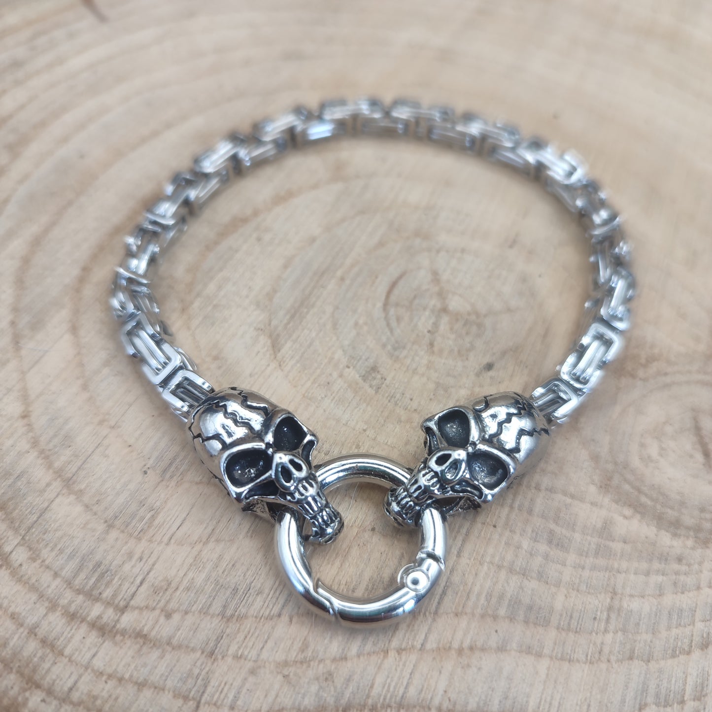 Detalle de la pulsera extendida mostrando las dos calaveras y el cierre