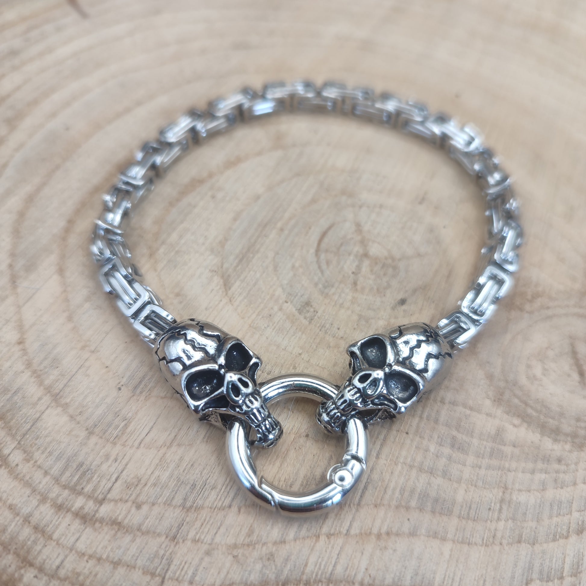 Detalle de la pulsera extendida mostrando las dos calaveras y el cierre