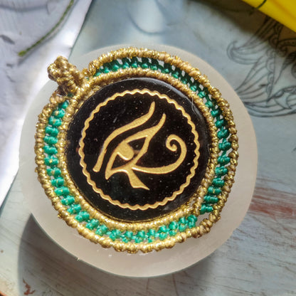 Primer plano del grabado místico del Ojo de Horus sobre espejo de obsidiana.