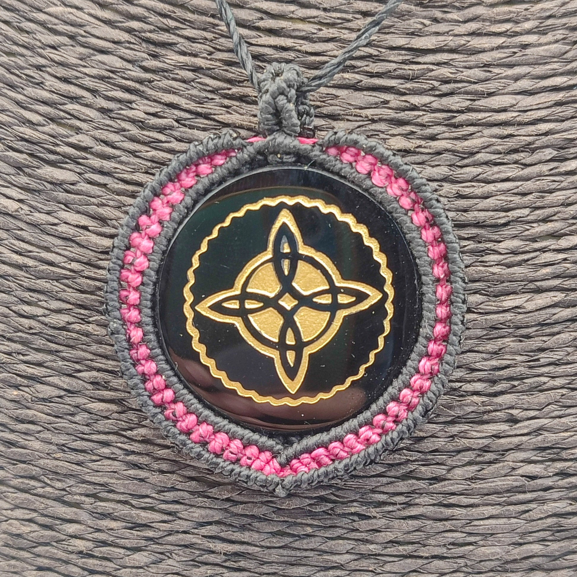 Primer plano del grabado dorado del Nudo de Bruja y el brillo vítreo de la piedra.